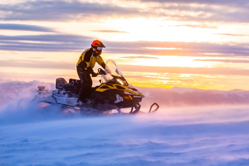 Snowmobile riding at sunset.